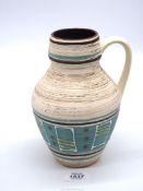 A West German pottery jug vase with hand applied red, white and yellow design over aqua blue centre,
