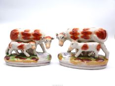 A pair of reproduction Staffordshire figures of cow and calf.