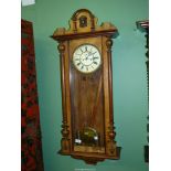 A twin weight Vienna regulator Wall Clock with decorative face having Roman numerals, 44'' high.