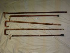 Five walking sticks including one with brass duck head handle,