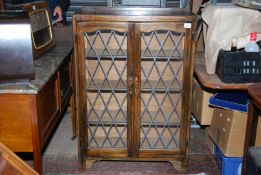 A floorstanding darkwood Cabinet having a pair of opposing lead lattice glazed doors,