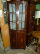 A Mahogany bow fronted display Cabinet on Cupboard with "H'' hinges and opposing inlaid detailed