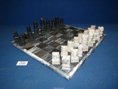A stone Chess board and pieces (one being a/f).