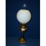 A brass Oil Lamp with brass reservoir and white glass shade, 21'' tall.
