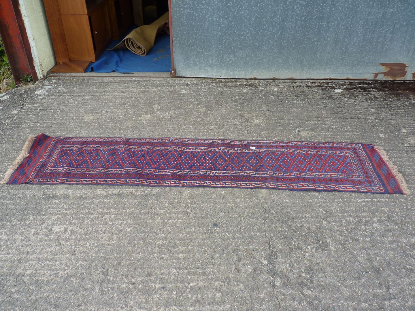 A geometric patterned Runner in blue and red, 103'' x 22''.