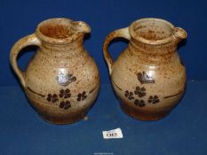 A pair of stoneware pottery jugs with bird and floral motifs, 7 1/2" tall.
