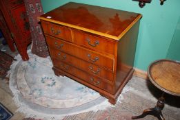 A compact Yewwood and other woods contemporary Chest of three long and two short drawers having