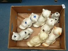 A quantity of Staffordshire style mantle cats including one sitting on a cushion.