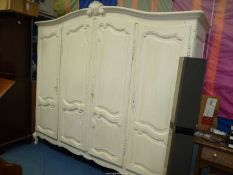 An imposing cream painted French design four door Wardrobe having shaped,
