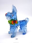 A large blue Murano 'Sckolie' dog with green ruffle and an orange bow.