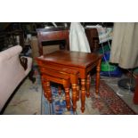 A contemporary honey Pine nest of three rectangular occasional Tables standing on turned legs,