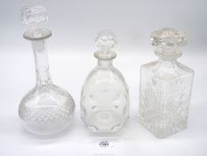 Three glass decanters including, bullseye, square shape and tall neck style.
