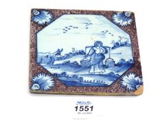 An 18th century English Delft tile painted in blue within a manganese border, chip to corner,