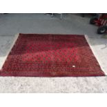 A hand knotted Afghan Bokhara rug in red and black, 48'' x 72''.