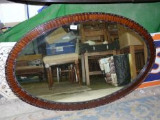 A large oval Mahogany framed Wall Mirror with small carved detail to the inner and outer edges of