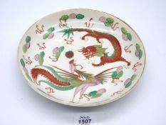 A Chinese shallow porcelain bowl decorated with Dragon and Hotto bird contesting a flaming pearl,