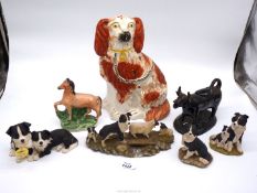 A Mantle spaniel, four border collie figures, Staffordshire flatbacks and black ceramic cow creamer.