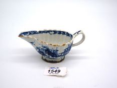 A small 18th century Bow porcelain sauce boat painted in blue, hair line crack, some chips to base.