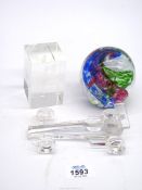 Three glass paperweights including multi coloured spiral, clear Formula 1 car and Spitfire detail.