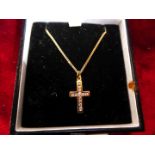 A yellow metal (unmarked gold?) pendant cross set with twelve white stones on a 9ct gold chain in