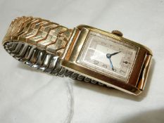 An Art Deco design 9 carat gold cased rectangular faced wristwatch with Arabic numerals and inset