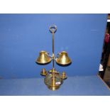 A brass double candlestick with small conical brass shades.