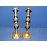 A pair of brass candlesticks with pushers, 11 1/4'' tall.