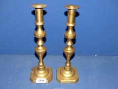 A pair of brass candlesticks with pushers, 11 1/4'' tall.