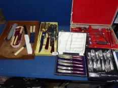 A large quantity of cutlery including cased butter knives, antler handle carving knife and fork,