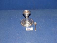 A Silver candlestick, Chester 1924, [some dents] together with a Silver salt spoon.