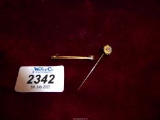 A 15ct gold stick pin with diamond chip, 1.03 gm., together with a rolled gold bar brooch.