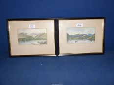A pair of framed and mounted Prints of Loch scenes with rowing boats and rocky mountains in the