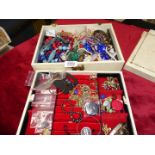 A quantity of costume jewellery in a white jewellery box including brooches,