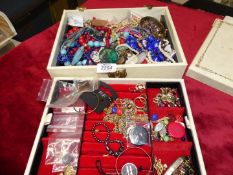 A quantity of costume jewellery in a white jewellery box including brooches,