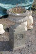 A concrete urn planter on pillar, 18" diameter x 35" high.