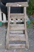 A vintage 4 rung wooden step ladder.