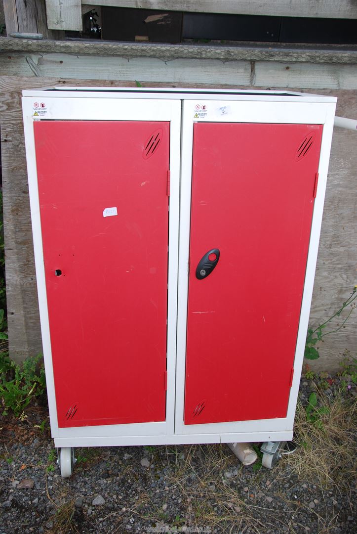 A storage cabinet with shelves on swivel castors, 30" x 18" x 47" high.