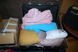 A suitcase containing blankets and cushions.