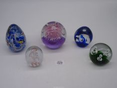 Five paperweights including pink sea urchin style with bubbles, dump shape with fish and waves,
