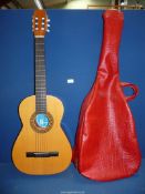 A Spanish acoustic guitar by Classico with soft red case.