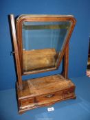 A hinged, free standing, dressing table bevelled mirror with three drawers to the base,