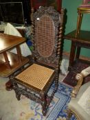 A profusely carved dark-wood Hall/side Chair having caned seat and backrest,