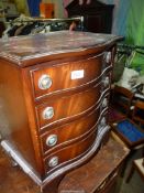 A compact contemporary bow fronted Chest of four short Drawers standing on bracket feet and having