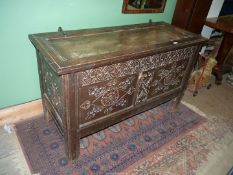 A peg joined two panel Oak blanket Chest decorated with carved stylised flower blooms and diamond