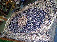 A large border pattern and fringed rug in blue ground with floral pattern, 77'' wide x 112'' long.