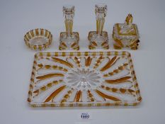 A pretty amber and clear glass dressing table set of candlesticks, trinket pot, ring dish and tray.