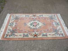 A peach and cream ground floral pattern Rug, 63'' x 35 1/2''.