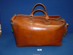 A good quality tan leather Holdall having a canvas lined interior and with a pair of carrying