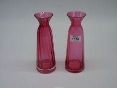 A pair of ruby red Dartington Crystal vases with narrow necks and flared rims,