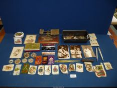 A tin baking tray containing miscellanea including a pen set, various old silk pictures,